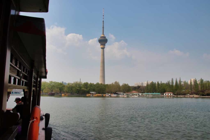 Fahrt mit dem Pendelboot über den See im Pekinger Yuyuantan-Park mit Blick auf den Fernsehturm.