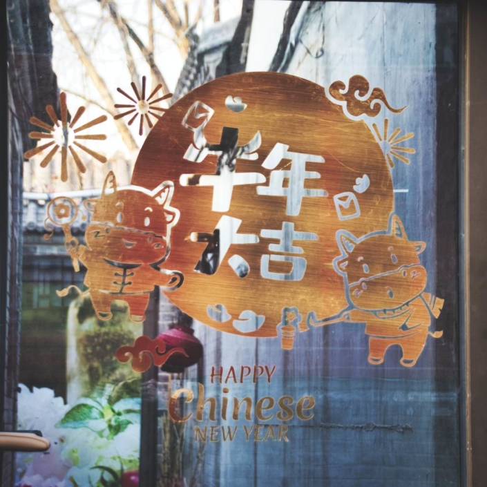 Goldene Neujahrsdeko an der Glastür eines Geschäfts im Pekinger Wudaoying-Hutong