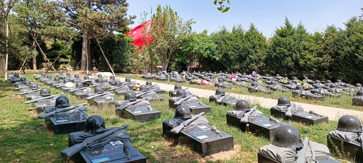 Babaoshan Revolutionsfriedhof. Grabplatten, die mit Helmen und Gewehren "verziert" sind.